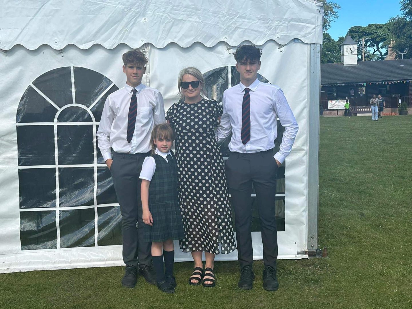Dean with mum Karina, brother Kai and sister Chelsea in smart clothes standing in front of a marquee
