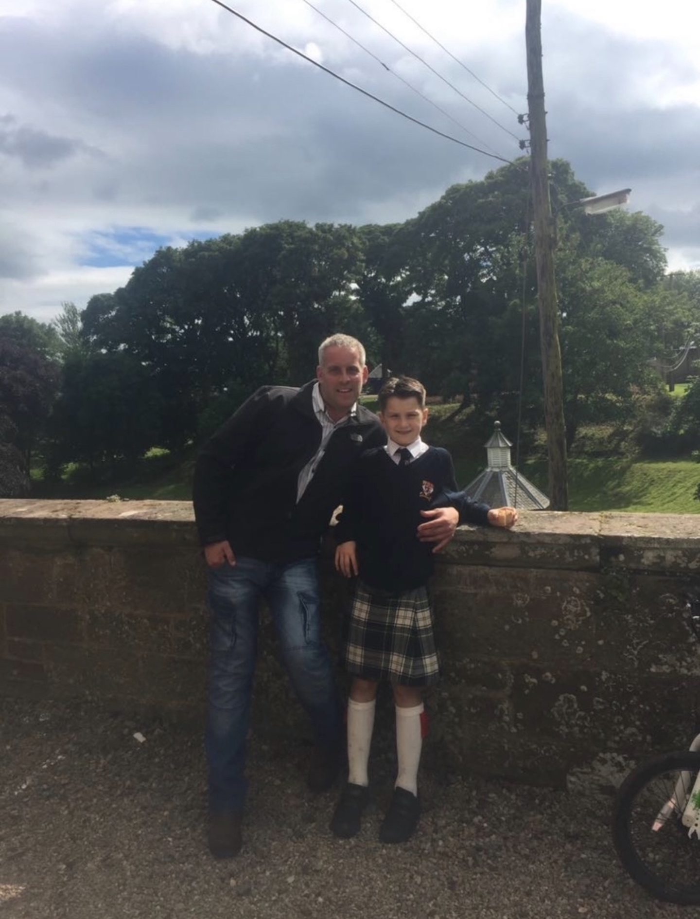 A man in jeans and a boy in a kilt