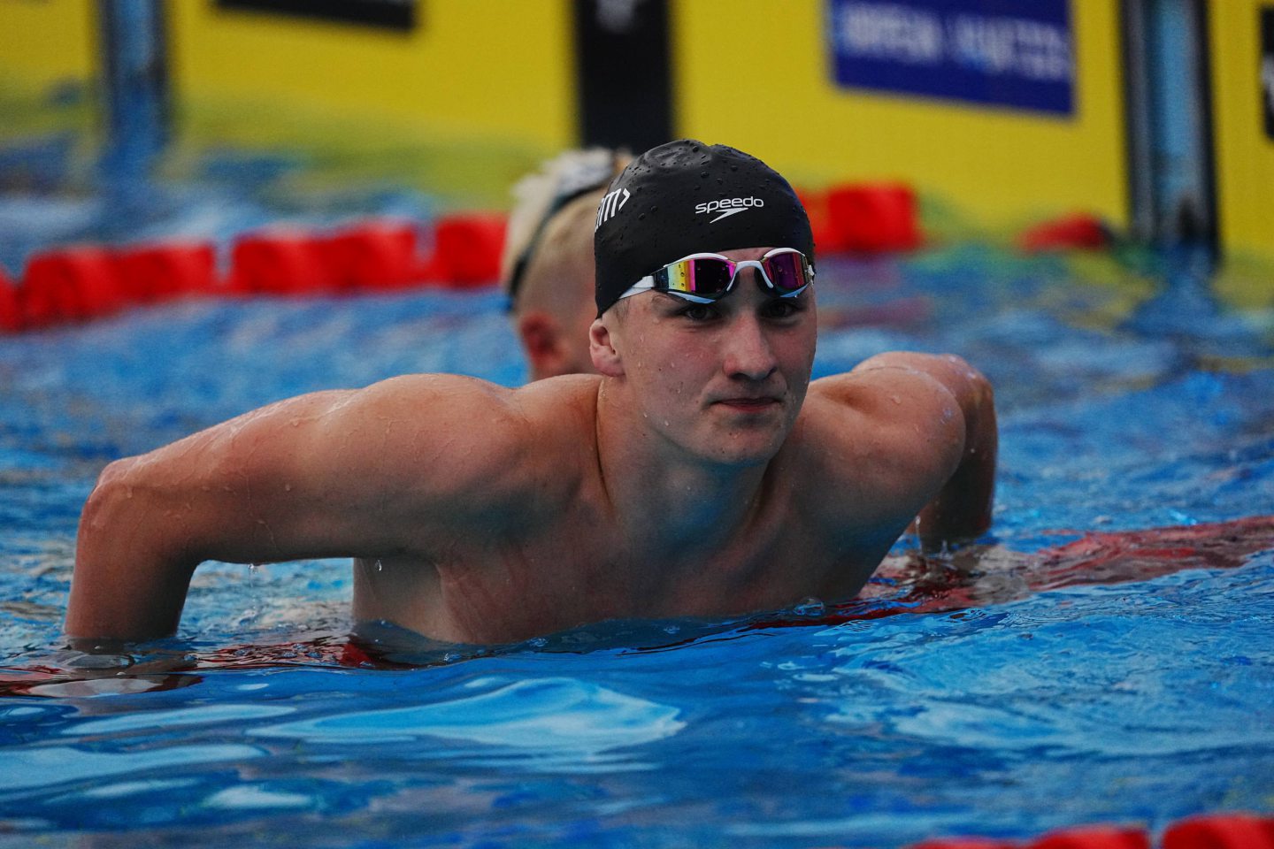 Dean in the pool leaning over a rope