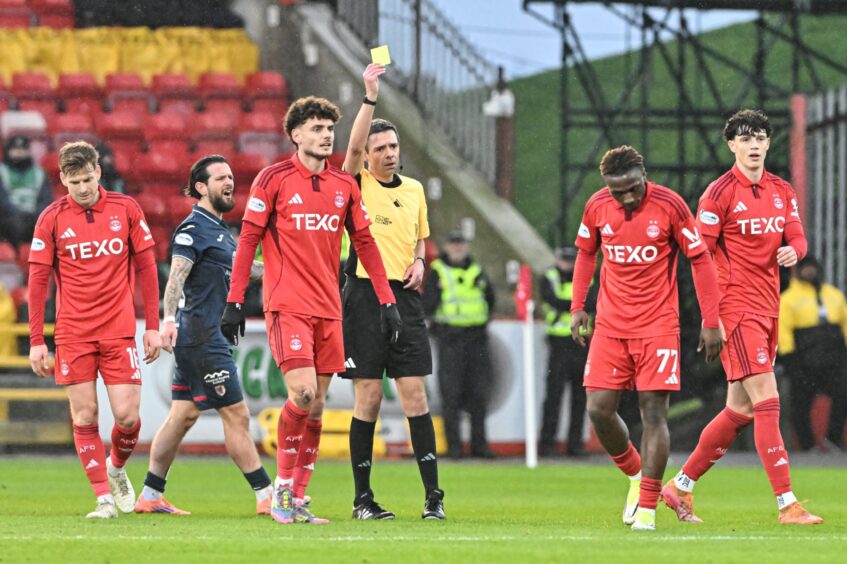 Emmanuel Gyamfi of Aberdeen is shown a yellow card by the match referee Kevin Clancy during the Scottish Gas Men's Scottish Cup fourth round match with Raith Rovers. Image: Shutterstock.
