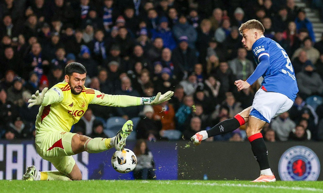 Aberdeen goalkeeper Dimitar Mitov (L) makes a save from Rangers' Connor Barron during 2-0 loss at Ibrox.