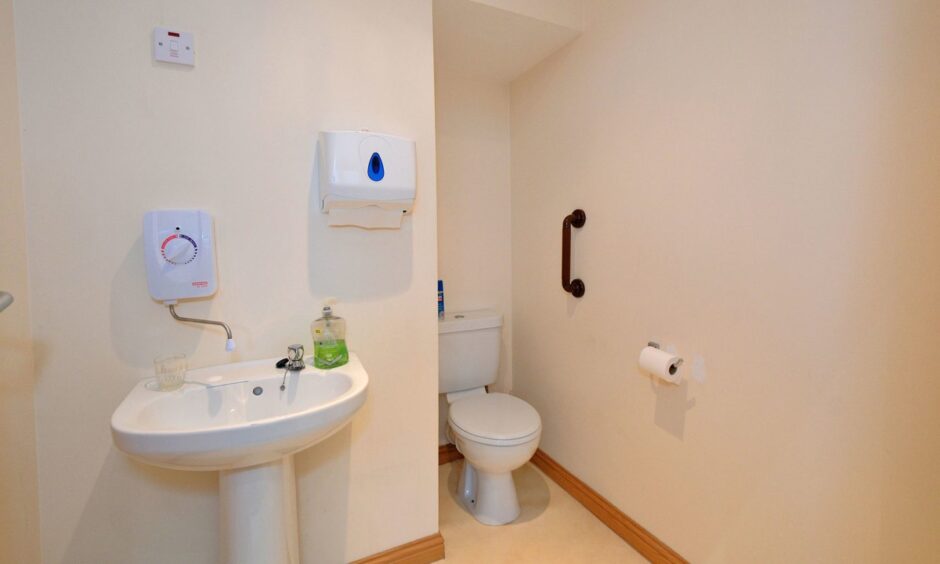 The WC is painted in cream and has a white suite.