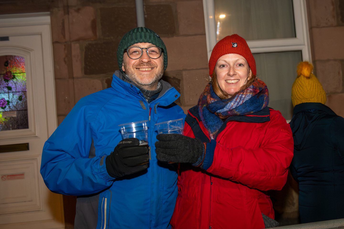 Matt and Holly clink drinks while celebrating the Stonehaven Fireballs event on Stonehaven High Street, January 1 2026.