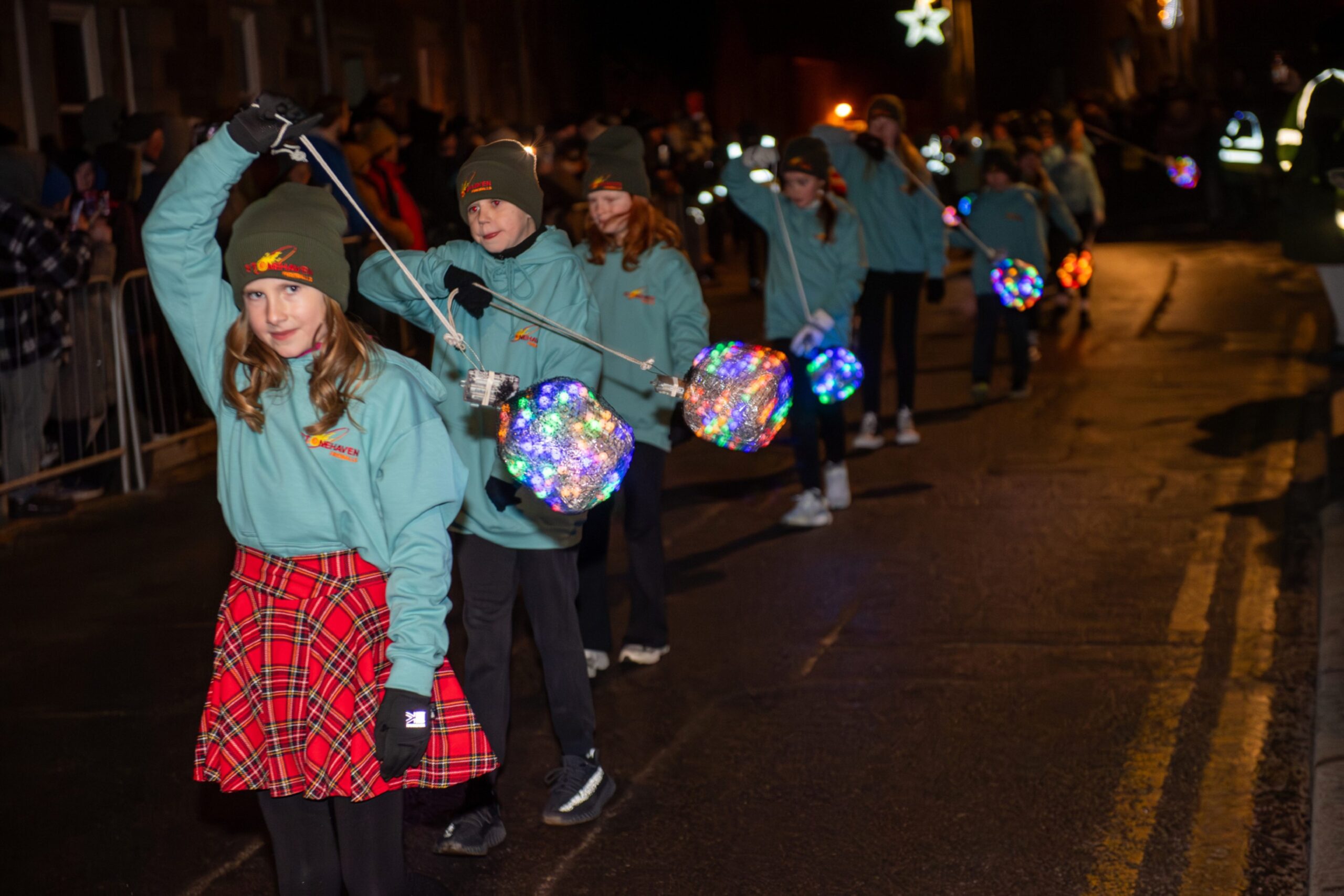 Junior fireball swingers carry illuminated fireballs while marching along Stonehaven High Street during the Stonehaven Fireballs Hogmanay celebrations, January 1 2026.