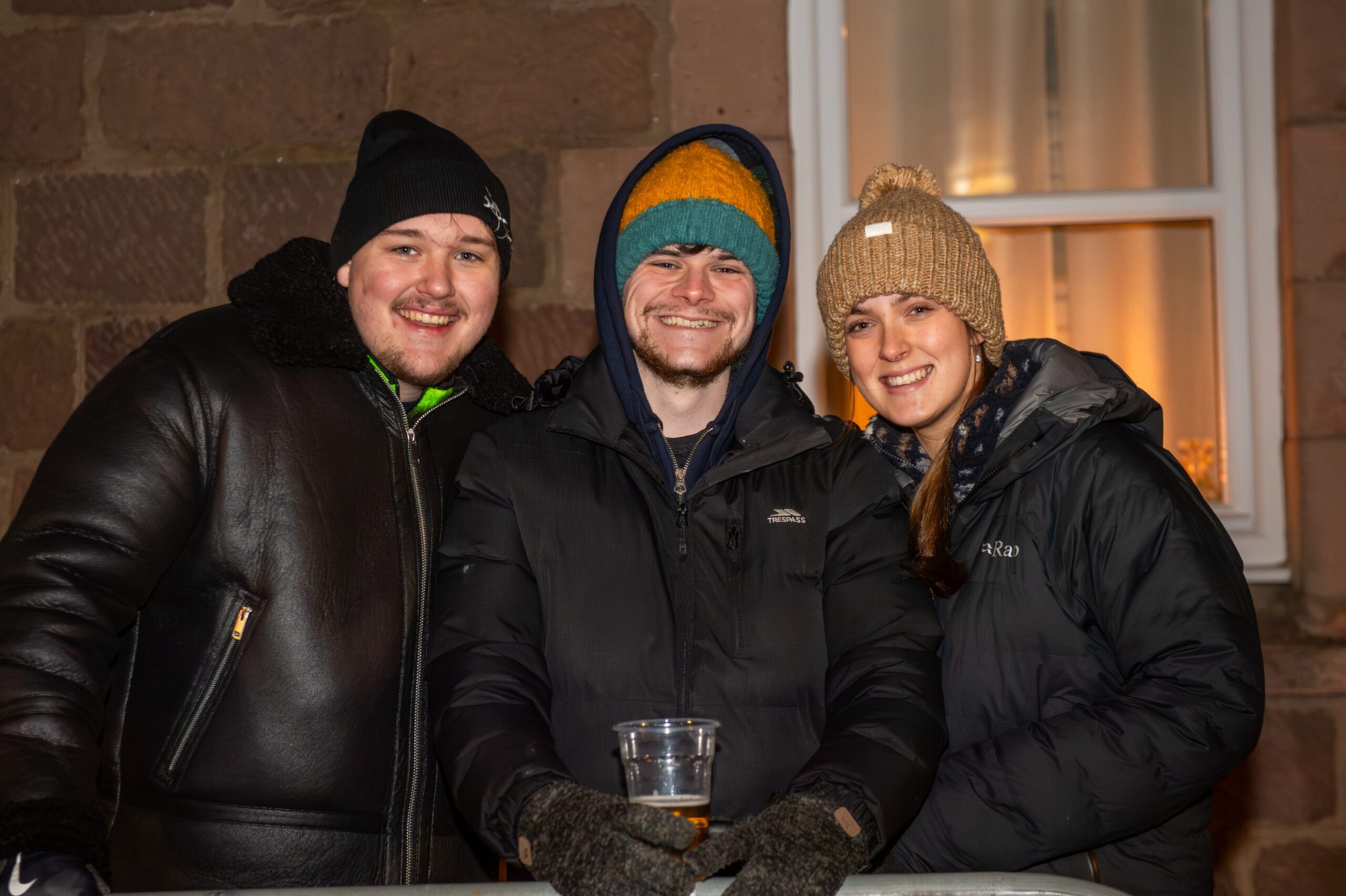 Callum, Garry and Jess stand together behind barriers during the Stonehaven Fireballs Hogmanay celebrations on Stonehaven High Street, January 1 2026.