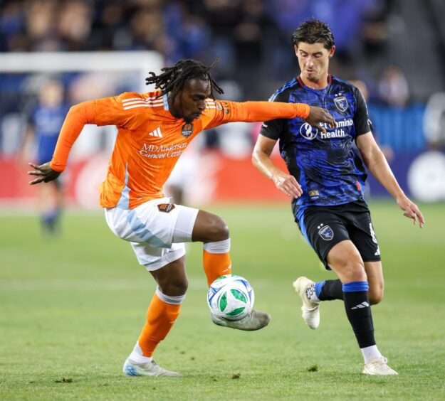 Toyosi Olusanya in action for Houston Dynamo, controlling the ball as a defender nears.