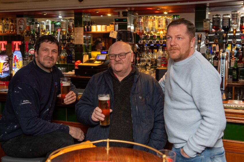 Michael Deans, Billy McKenzie and Barry Mitchell standing at bar.