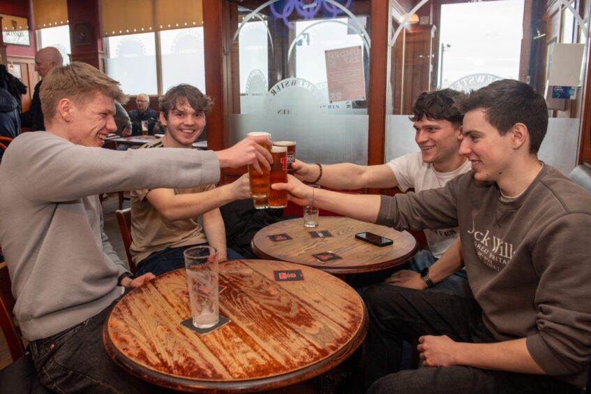 Group of people toasting drinks.