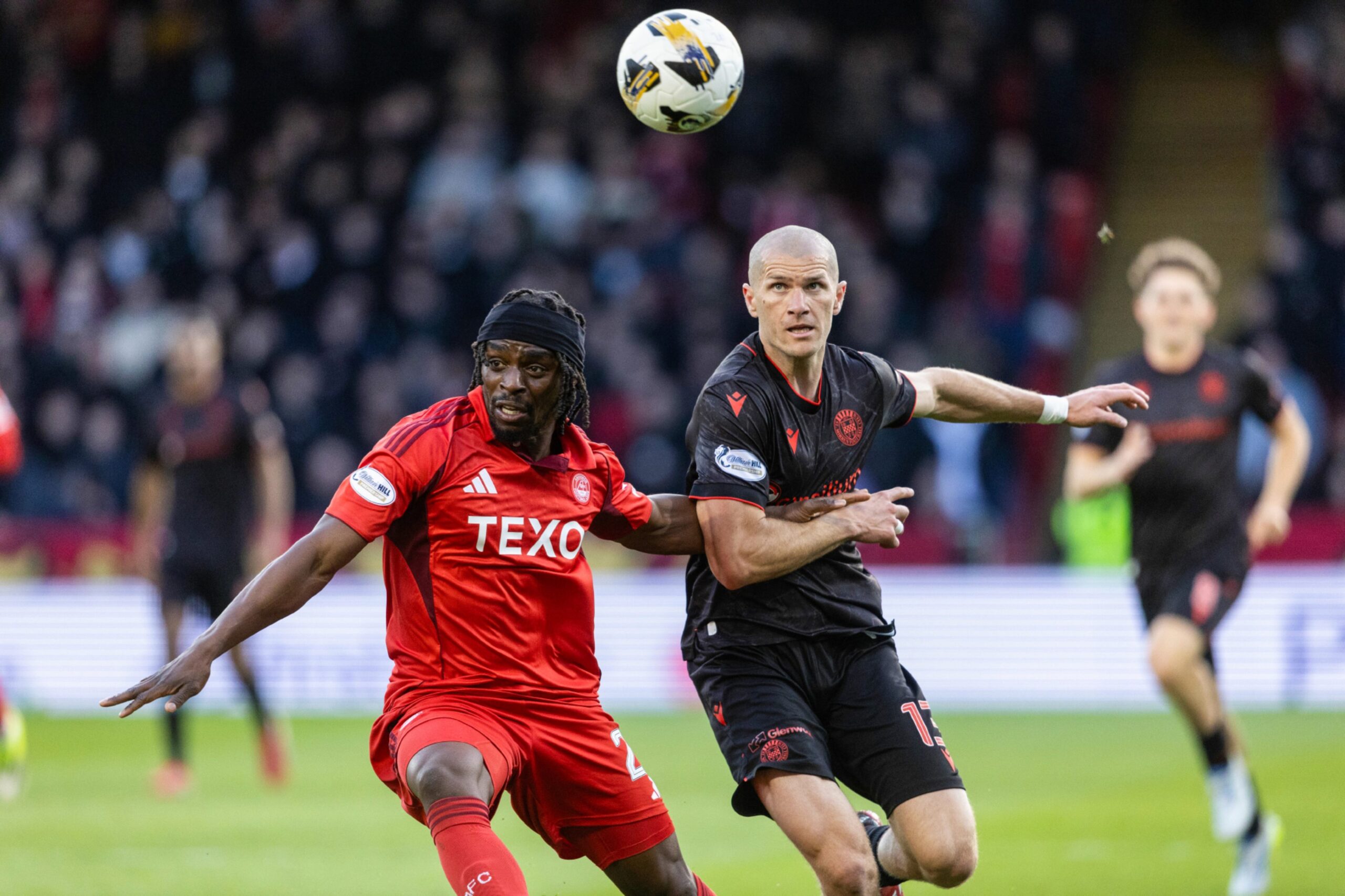 Aberdeen's Toyosi Olusanya (L) and St Mirren's Alex Gogic (R) in action at Pittodrie. 
