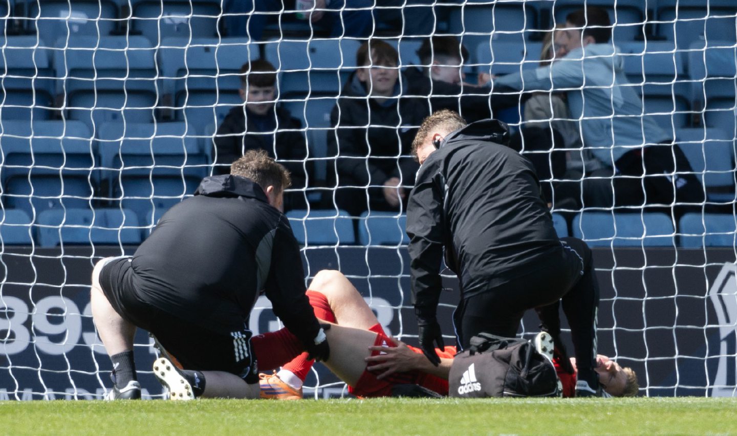 Aberdeen's Mats Knoester is forced off with an injury against Dundee at Dens Park. 