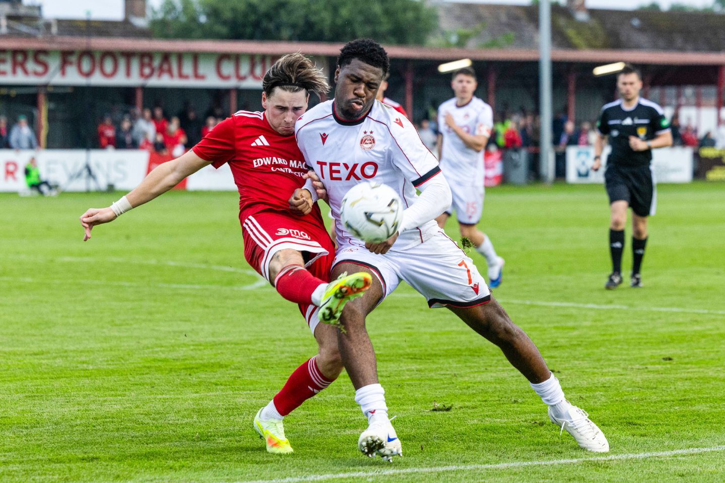 Aberdeen's Tony Yogane and Brora's Gary Pullen in action during a Premier Sports Cup group stage match.
