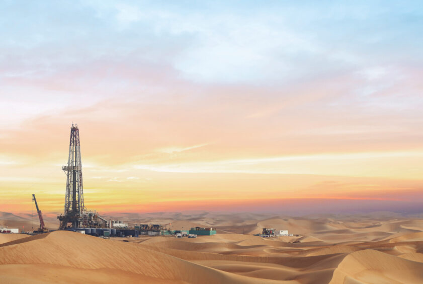 Drilling rig on the left hand side amid sand dunes