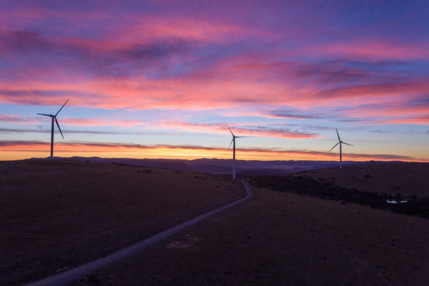 Three wind turbines against a dawn sky