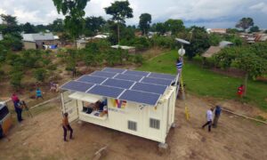 Shipping container with solar panels on the roof in a village