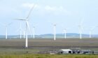 Wind turbines and electricity pylons carrying their electricity on the Causeymire in Caithness.