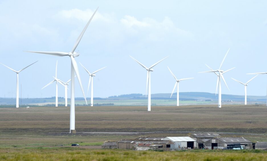 Wind turbines and electricity pylons carrying their electricity on the Causeymire in Caithness.