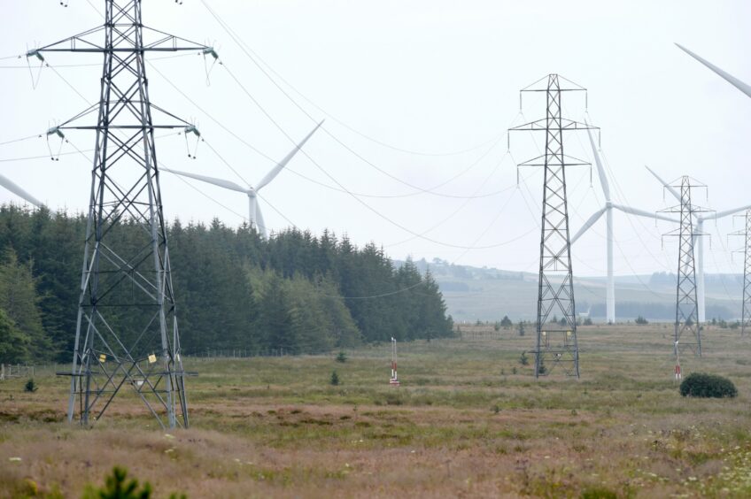 Wind turbines and electricity pylons carrying their electricity on the Causeymire in Caithness.