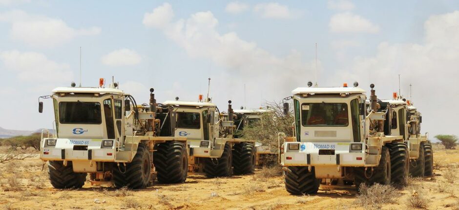 Big trucks in dusty landscape