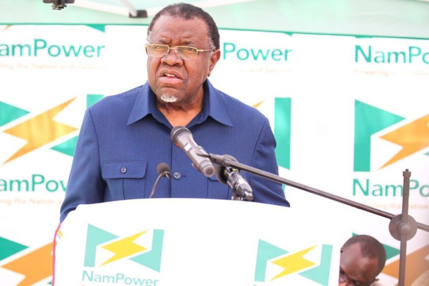 Man stands at podium in front of Nampower signs