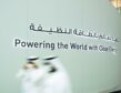 Powering the world with clean energy slogan on big wall, with two motion blurred people in front
