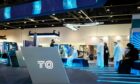 TQ logo in front with blue conference stand behind