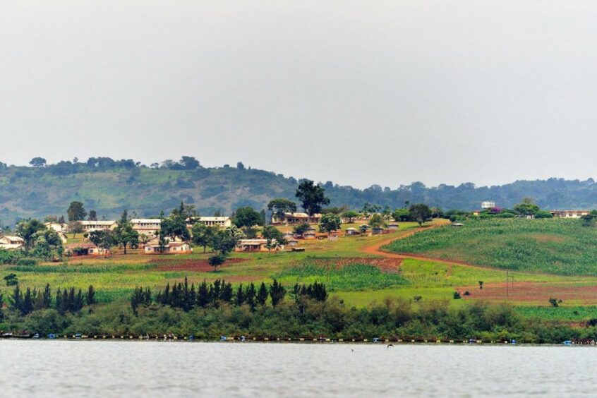 Lake in the foreground, green rolling hills behind