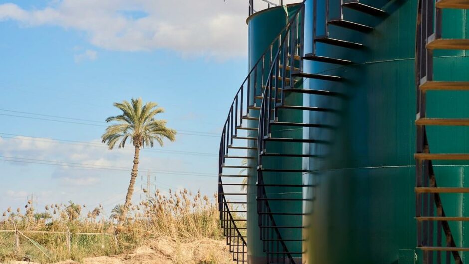 Tree on left hand side, green industrial tank on the right