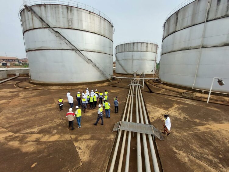 Storage tanks with people in high vis jackets