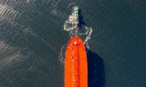 A tug boat tows an AET Tankers Pte liquid natural gas (LNG) dual-fuelled aframax vessel near the Samsung Heavy Industries Co. shipyard in this aerial photograph taken in Geoje, South Korea, on Friday, Feb. 1, 2019. Korea Development Bank (KDB) has contacted Samsung Heavy on whether it would be interested in Daewoo Shipbuilding & Marine Engineering Co. before the bank makes a definitive decision on its stake. Samsung Heavy will review KDB's proposal for Daewoo, the company said in a text message.