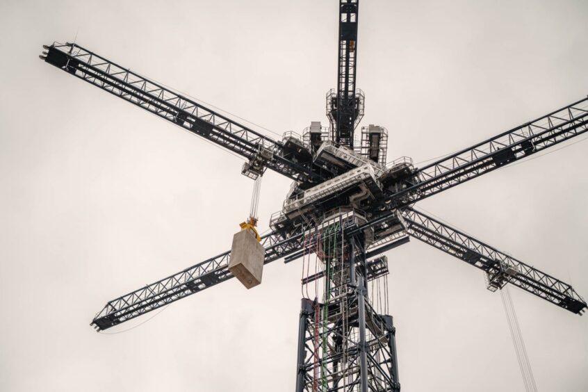 Crane with four arms lifting blocks