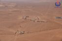 Aerial shot of desert with buildings and drilling activity
