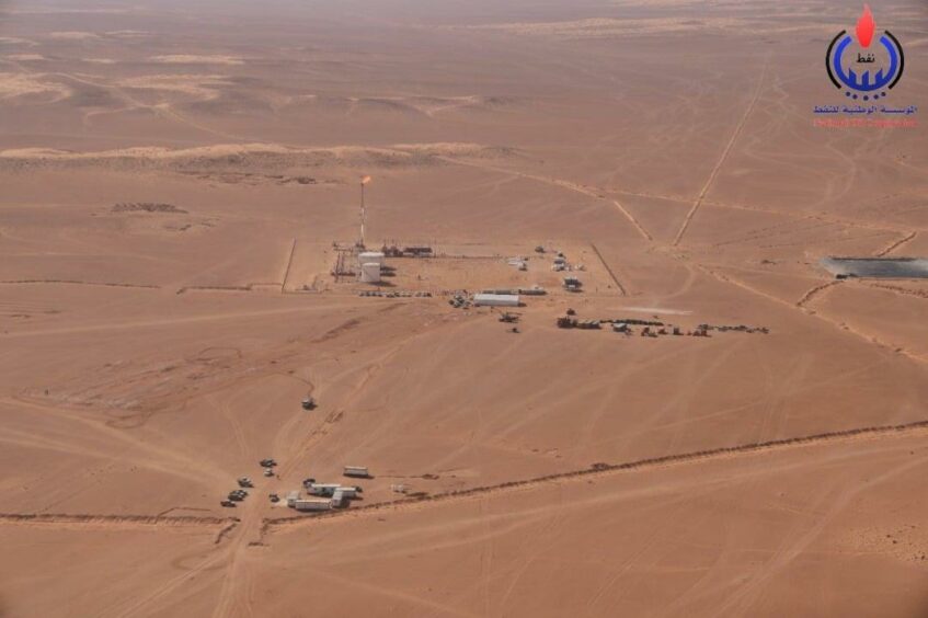 Aerial shot of desert with buildings and drilling activity 