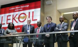 People stand on balcony in front of display saying Lekoil