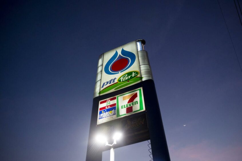 Signage for a PTT Pcl gas station stands illuminated in Bangkok, Thailand, on Thursday, Feb. 11, 2016.  Photographer: Brent Lewin/Bloomberg