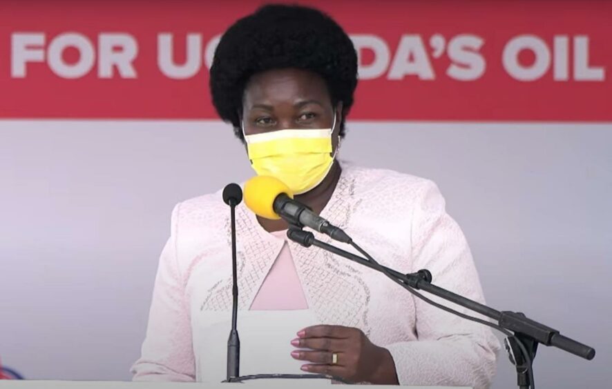 Woman in yellow mask speaks into mic