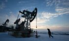 An oil worker inspects a pumping jack, also known as a 'nodding donkey,' during drilling operations in an oilfield operated by Bashneft PAO in the village of Otrada, 150kms from Ufa, Russia, on Saturday, March 5, 2016. Photographer: Andrey Rudakov/Bloomberg