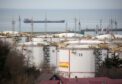 Oil storage tanks stand at the RN-Tuapsinsky refinery, operated by Rosneft Oil Co., as a tanker sails beyond in Tuapse, Russia, on Monday, March 23, 2020.