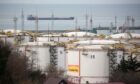 Oil storage tanks stand at the RN-Tuapsinsky refinery, operated by Rosneft Oil Co., as a tanker sails beyond in Tuapse, Russia, on Monday, March 23, 2020.