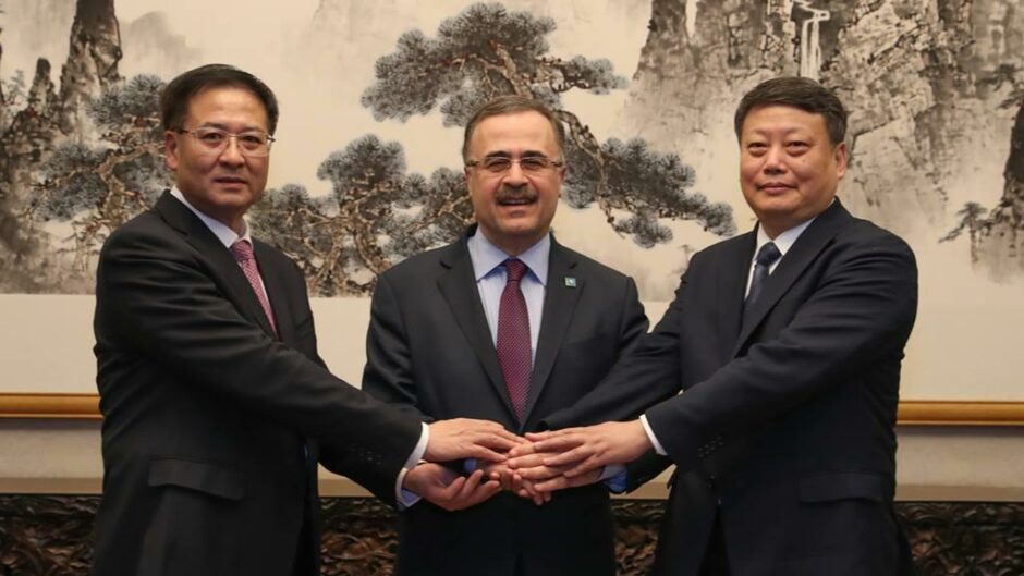 Three men hold hands and smile