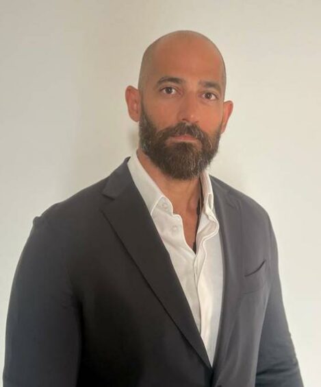 Headshot of man with jacket and no tie