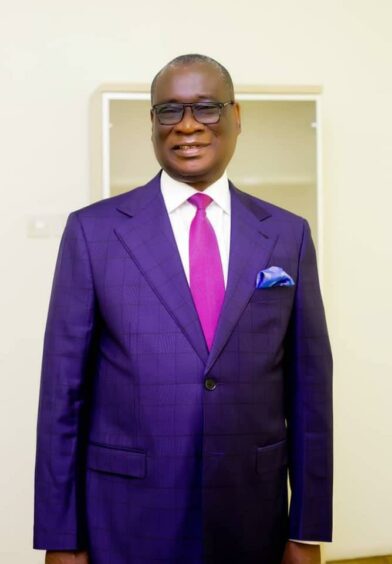 Man in purple suit and glasses 