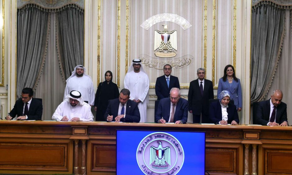 People behind a desk signing documents