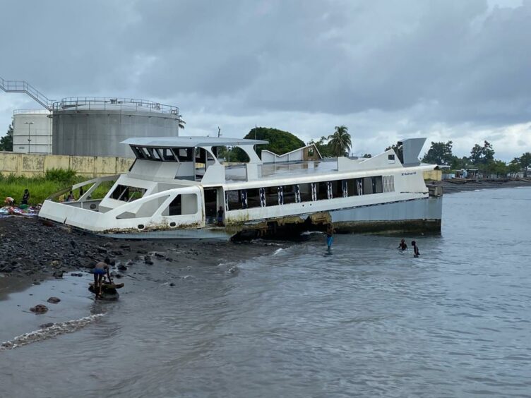 Catamaran wrecked with children playing around it