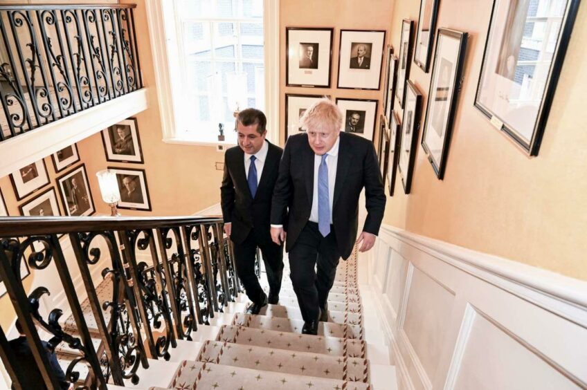Two men walk up stairs