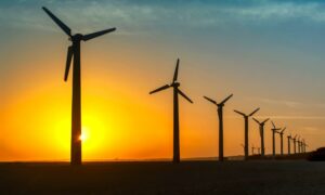 Wind turbines generating electric power with renewable energy against golden sunset at Mandvi seaside ,Kutch, Gujarat, India.