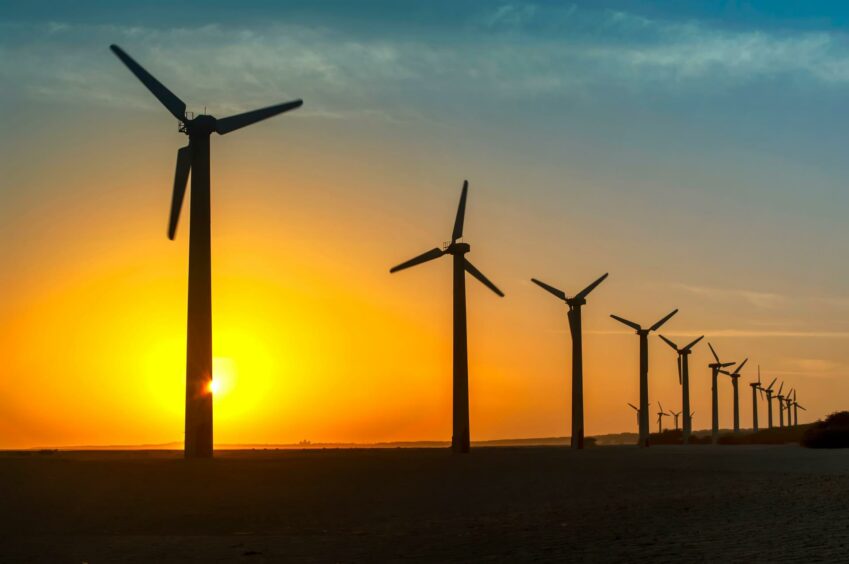 Wind turbines generating electric power with renewable energy against golden sunset at Mandvi seaside ,Kutch, Gujarat, India.