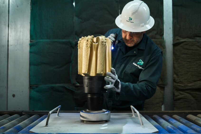 Baker Hughes Oilfield Services employee inspecting a drill bit.