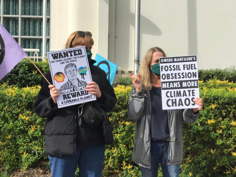 Two protesters holding placards opposed to offshore seismic