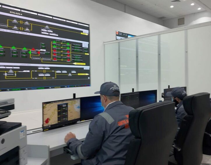 Man sits at desk looking at pipeline monitor