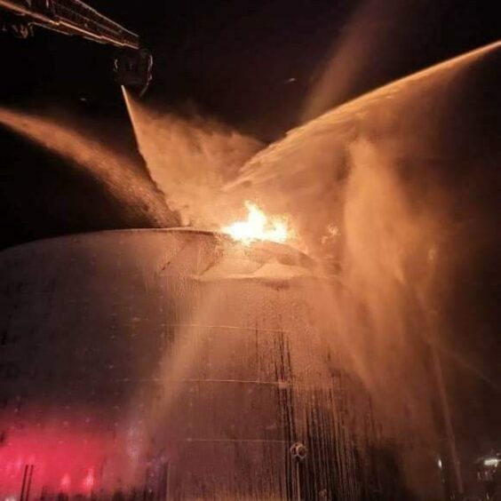 A fire at a storage tank with a number of water streams attempting to extinguish them